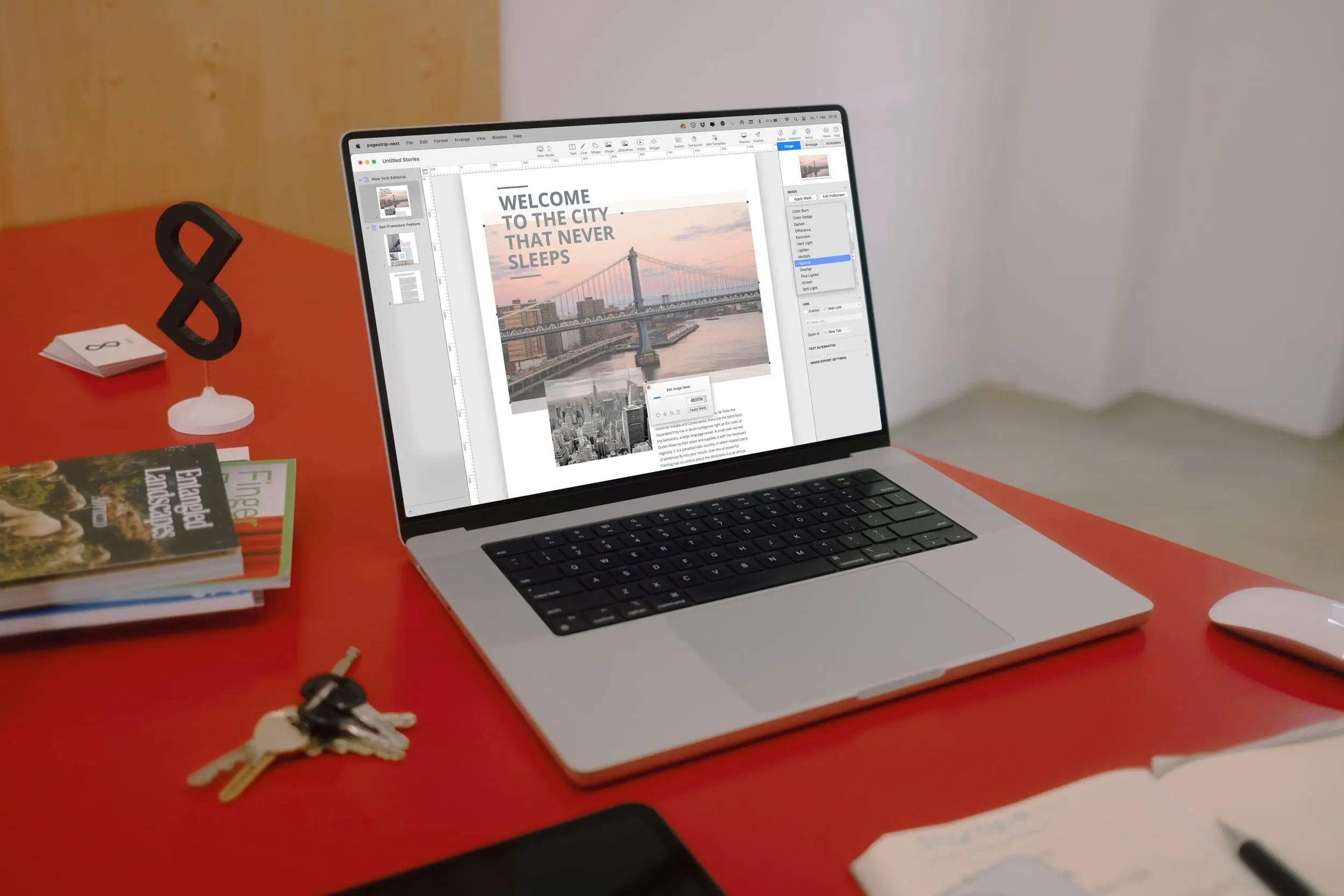 A still image of the pagestrip office, showing a MacBook Pro running the pagestrip app and various everyday items scattered on a red table.